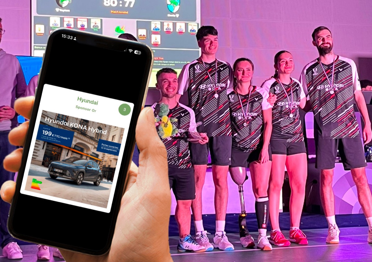 L'offre d'un sponsor s'affiche dans le téléphone d'un fan, devant une équipe sur le podium